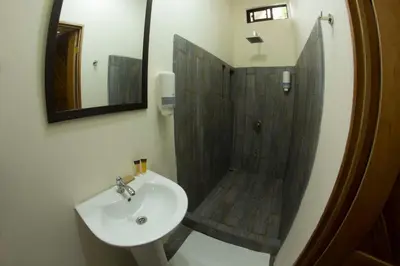 a bathroom with a sink and a shower with a mirror at Villas Fernanda #2 in Fortuna