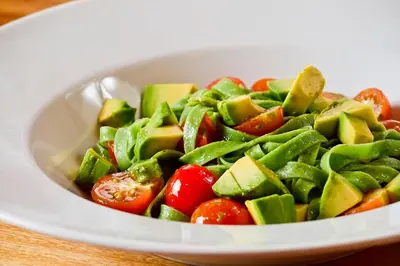 a bowl of vegetables with tomatoes and cucumbers at Villas Fernanda #2 in Fortuna
