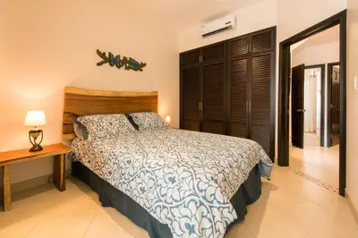 a bedroom with a bed and a night stand and a table at Cabo Velas Estates 30 in Matapalo