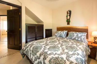 a bedroom with a bed with a comforter at Cabo Velas Estates 30 in Matapalo