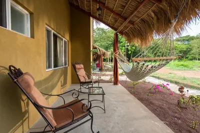 a porch with two chairs and a hammock on a house at Cabo Velas Estates 30 in Matapalo