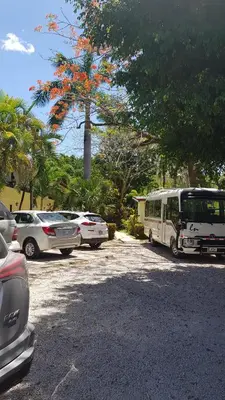 a parking lot with parked cars and a bus at Samara Beach Hotel in Sámara