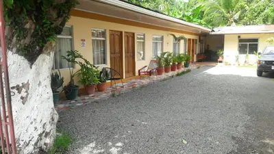 a house with potted plants on the side of it at Cabinas Doña Alicia in Quepos