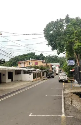 a street with a car parked on the side of the road at Cabinas Doña Alicia in Quepos