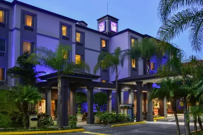 a hotel with a clock tower on top of it at Sleep Inn Paseo Las Damas in San José