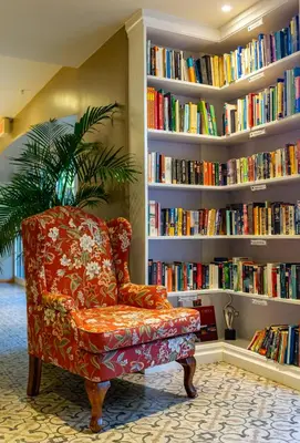 a chair in a library with shelves of books at Sleep Inn Paseo Las Damas in San José