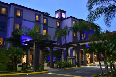 a building with a clock tower on top of it at Sleep Inn Paseo Las Damas in San José