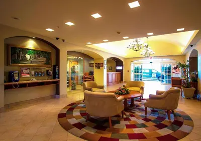 a lobby with a waiting room with chairs and a table at Sleep Inn Paseo Las Damas in San José