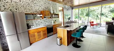 a kitchen with a refrigerator and a table and chairs at Hotel Plaza Yara in Manuel Antonio
