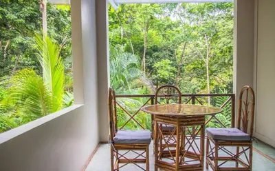 a balcony with a table and chairs and a window at Hotel Plaza Yara in Manuel Antonio
