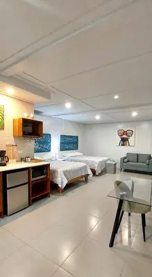 a large room with a bed and a kitchen and a room with a bed gmaxwell at Hotel Plaza Yara in Manuel Antonio