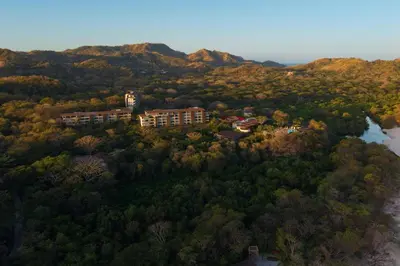an aerial view of a building on a hill with trees at W Costa Rica Resort – Playa Conchal in Playa Conchal