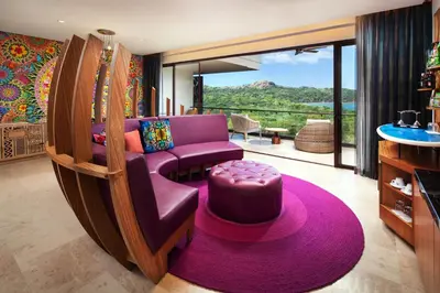 a living room with a purple couch and a large window at W Costa Rica Resort – Playa Conchal in Playa Conchal