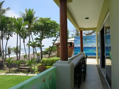 a view of the beach from the balcony of a house at Surf Inn Hermosa in Playa Hermosa