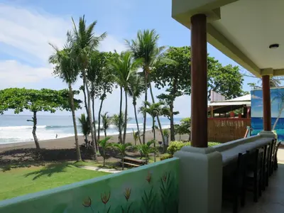 a view of the beach from the balcony of a resort at Surf Inn Hermosa in Playa Hermosa