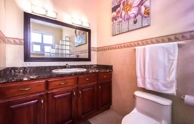 a bathroom with a sink and a toilet and a mirror at Surf Inn Hermosa in Playa Hermosa