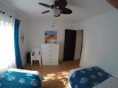 a bedroom with a bed and a ceiling fan at Coco Beach Home in Coco
