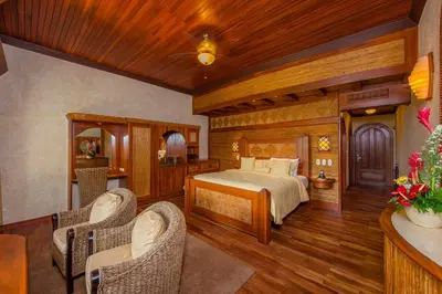 a bedroom with a bed and two chairs at The Springs Resort & Spa at Arenal in Fortuna