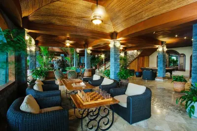 a lobby with chairs and a chess board on a table at The Springs Resort & Spa at Arenal in Fortuna