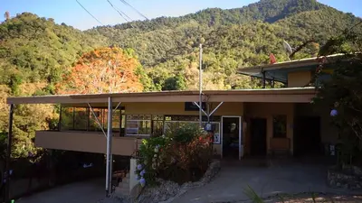 a building with a mountain in the background at Hotel Uran in Rivas