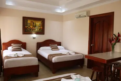 a hotel room with two beds and a table at Hotel SueñoReal RioCeleste in Rio Celeste