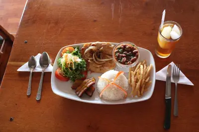 a plate of food on a wooden table at Hotel SueñoReal RioCeleste in Rio Celeste