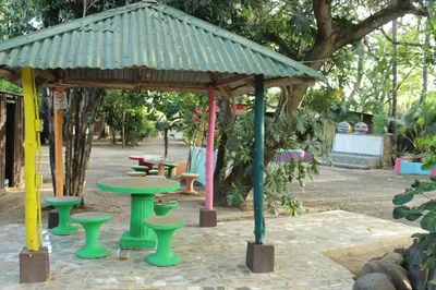 a gazebo with a table and chairs in a park at Hostalito El Greco in Bagaces