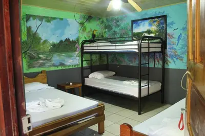 two bunk beds in a room with a mural at Hostalito El Greco in Bagaces