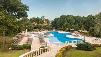 a resort with a pool and chairs and trees at Occidental Papagayo - Adults Only All Inclusive in Papagayo, Guanacaste