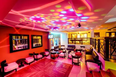 a room with a bar with purple lights on the ceilings at Occidental Papagayo - Adults Only All Inclusive in Papagayo, Guanacaste