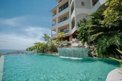 a swimming pool in front of a building with a water fountain at Parador Nature Resort and Spa in Manuel Antonio