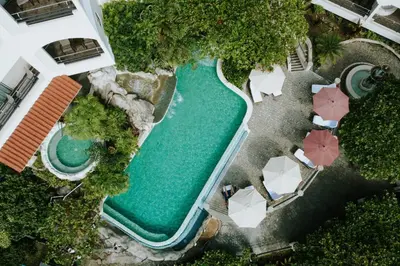 an overhead view of a swimming pool with umbrellas at Parador Nature Resort and Spa in Manuel Antonio