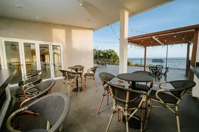 a patio with tables and chairs and a view of the ocean at Parador Nature Resort and Spa in Manuel Antonio