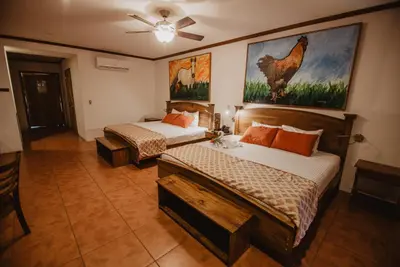 a bedroom with two beds and a ceiling fan at Hacienda Guachipelin Volcano Ranch Hotel & Hot Springs in Liberia
