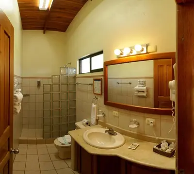 a bathroom with a sink and a mirror and a toilet at Cristal Ballena Boutique Hotel & Spa in Uvita