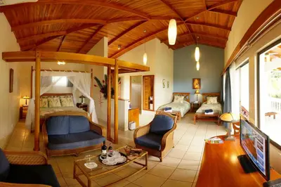 a bedroom with two beds and a living room at Cristal Ballena Boutique Hotel & Spa in Uvita