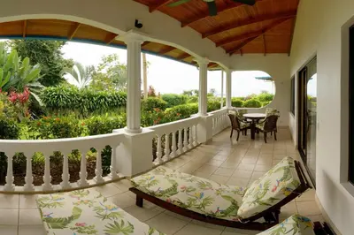 a porch of a house with a table and chairs at Cristal Ballena Boutique Hotel & Spa in Uvita