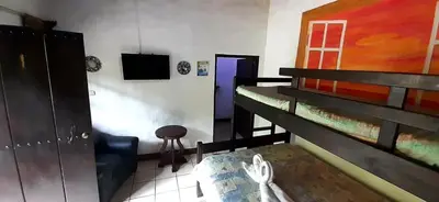 a room with two bunk beds and a door with a stool at Hotel Monte Campana Heredia in Birrí