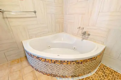 a bath tub in a bathroom with a tiled floor at Hotel San Bada Resort & Spa in Manuel Antonio