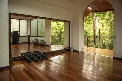 an empty room with a gym with wood floors and large windows at Hotel San Bada Resort & Spa in Manuel Antonio