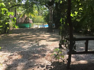 a path with a fence and trees and a building at Mal Pais Surf Camp in Santa Teresa Beach