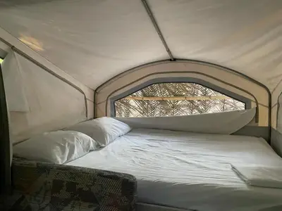 a bed in a tent with a window at Mal Pais Surf Camp in Santa Teresa Beach