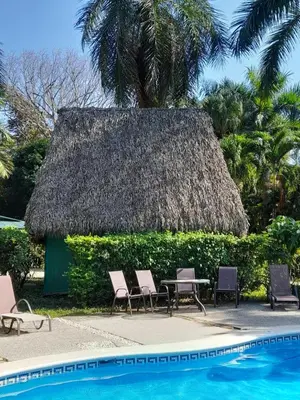 a resort with a table and chairs next to a swimming pool at Mal Pais Surf Camp in Santa Teresa Beach