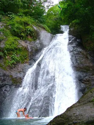 a man on a surfboard in front of a waterfall at Adventure Park & Hotel Vista Golfo in Tajo Alto