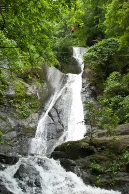 a waterfall with a person standing on top of it at Adventure Park & Hotel Vista Golfo in Tajo Alto