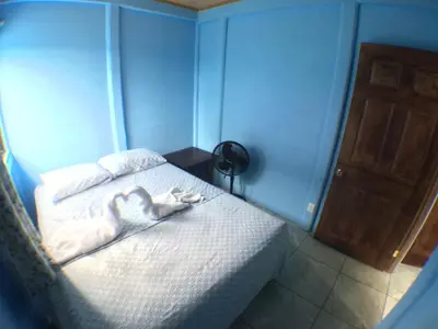 a bedroom with a bed with two hearts on it at Green Macaw Hostel in Tortuguero