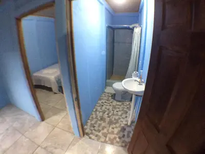 a small bathroom with a toilet and a sink at Green Macaw Hostel in Tortuguero