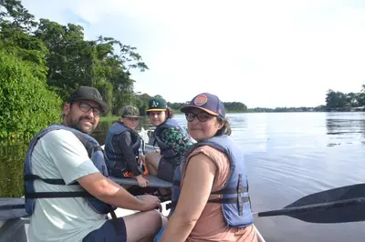 a group of people in a boat on the water at Green Macaw Hostel in Tortuguero