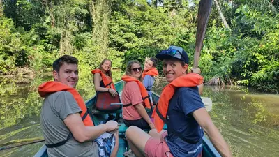 a group of people in a raft on a river at Green Macaw Hostel in Tortuguero