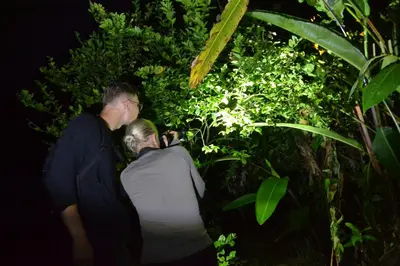 two people standing in front of a plant at Green Macaw Hostel in Tortuguero